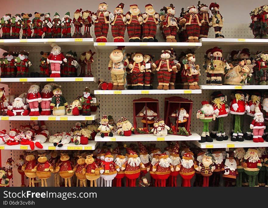 Variety of Christmas dolls on shelves.