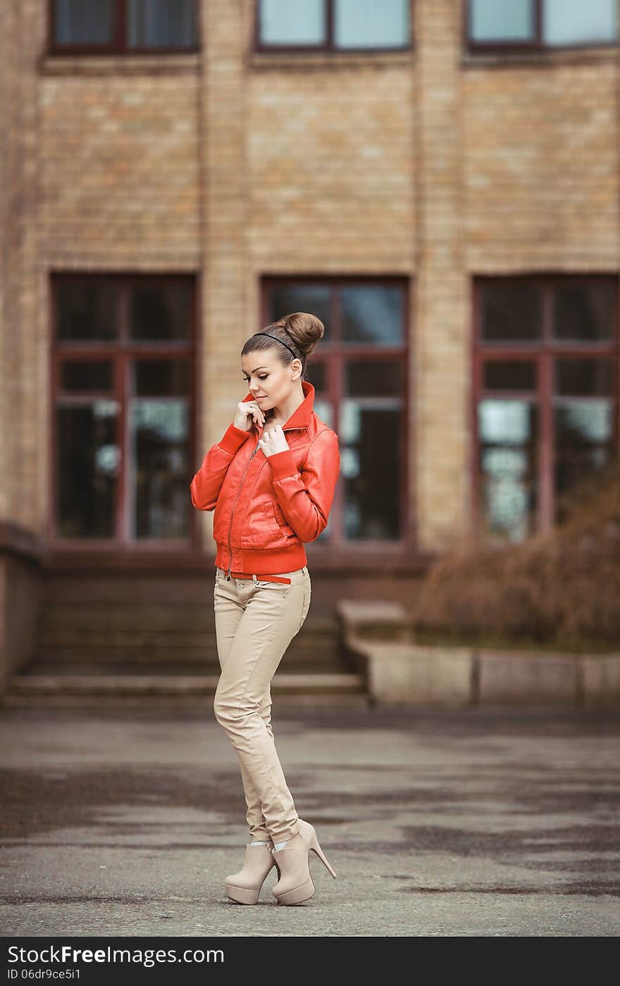 Beautiful woman in a red jacket posing on a big city background. Beautiful woman in a red jacket posing on a big city background