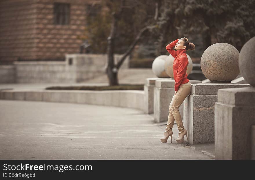 Beautiful woman in a red jacket posing on a big city background. Beautiful woman in a red jacket posing on a big city background