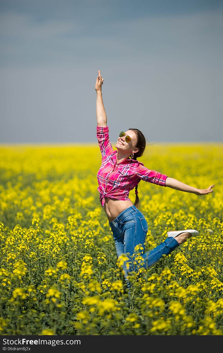 Young beautiful woman in flowering field in summer. Outdoors