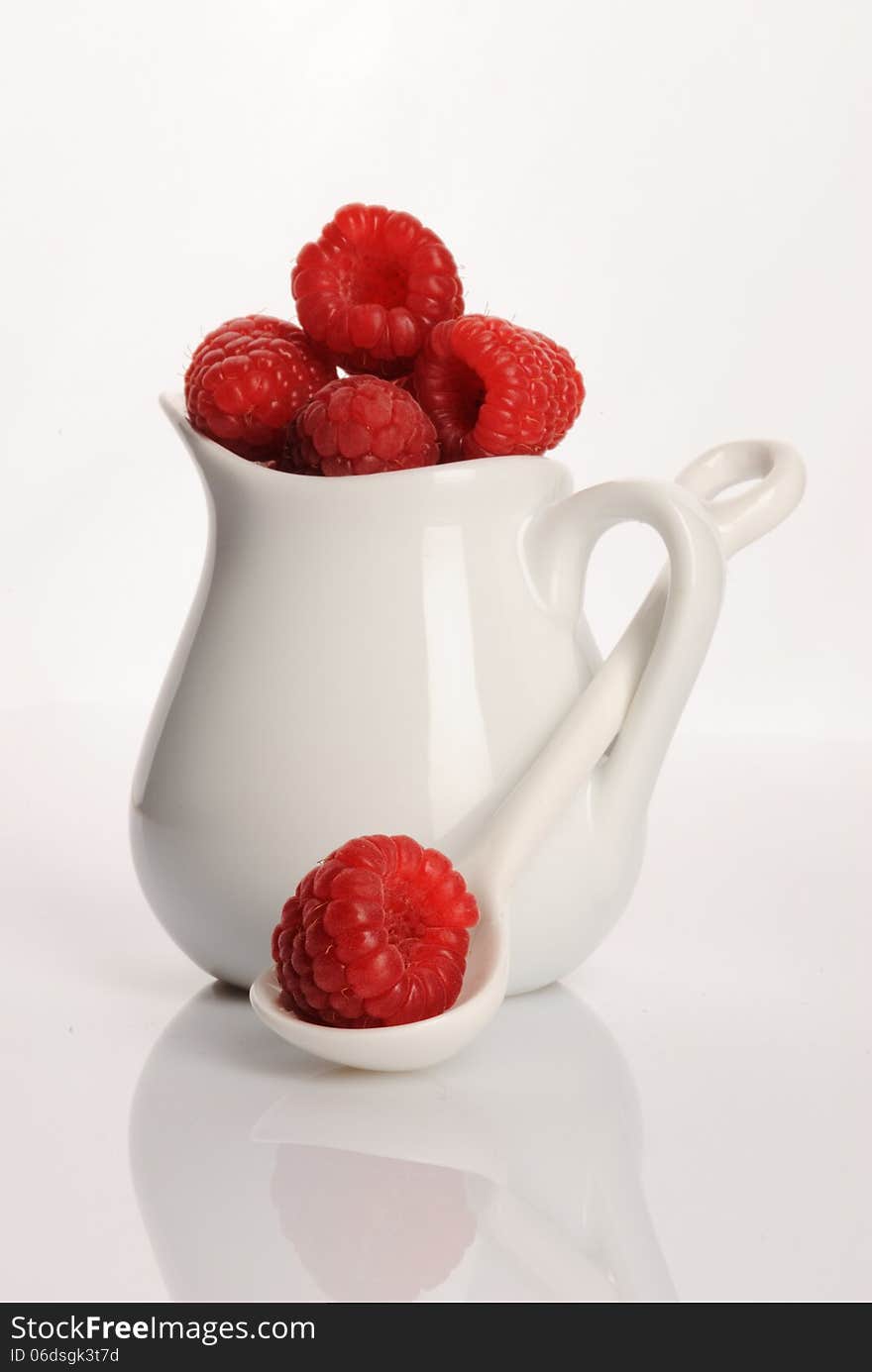 Small jug with fresh raspberry by a breakfast. Small jug with fresh raspberry by a breakfast