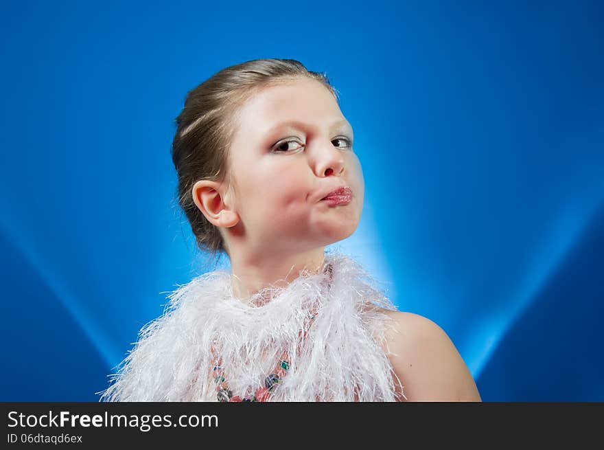 Beautiful girl in the blue background coated with face makeup. Beautiful girl in the blue background coated with face makeup