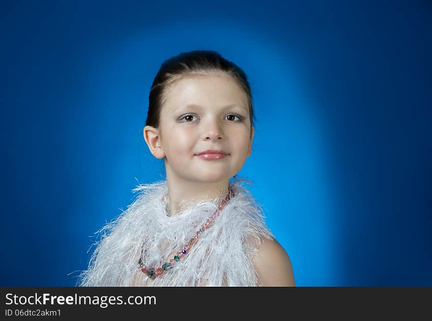 Beautiful girl in the blue background coated with face makeup. Beautiful girl in the blue background coated with face makeup