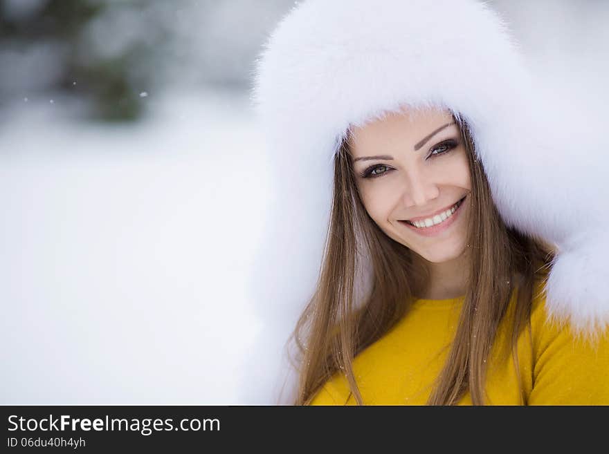 Winter Portrait Of Beautiful Smiling Woman With Snowflakes In White Furs