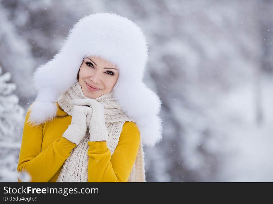 Winter Portrait Of Beautiful Smiling Woman With Snowflakes In White Furs