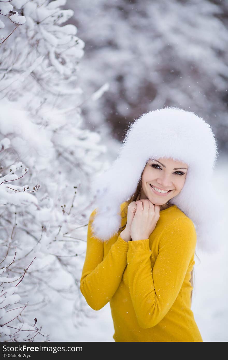 Winter Portrait Of Beautiful Smiling Woman With Snowflakes In White Furs