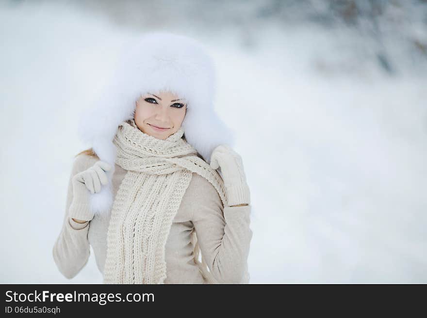 Winter Portrait Of Beautiful Smiling Woman With Snowflakes In White Furs