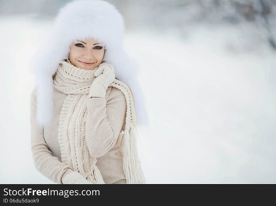 Winter Portrait Of Beautiful Smiling Woman With Snowflakes In White Furs