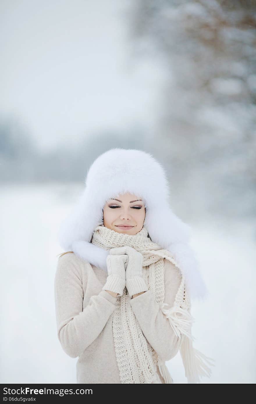 Winter Portrait Of Beautiful Smiling Woman With Snowflakes In White Furs