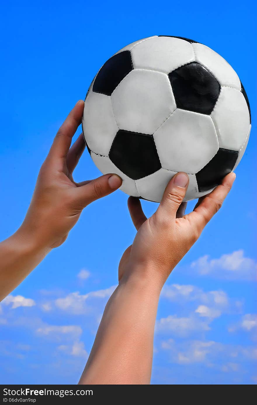 Football Ball In Man Hand On Blue Sky.