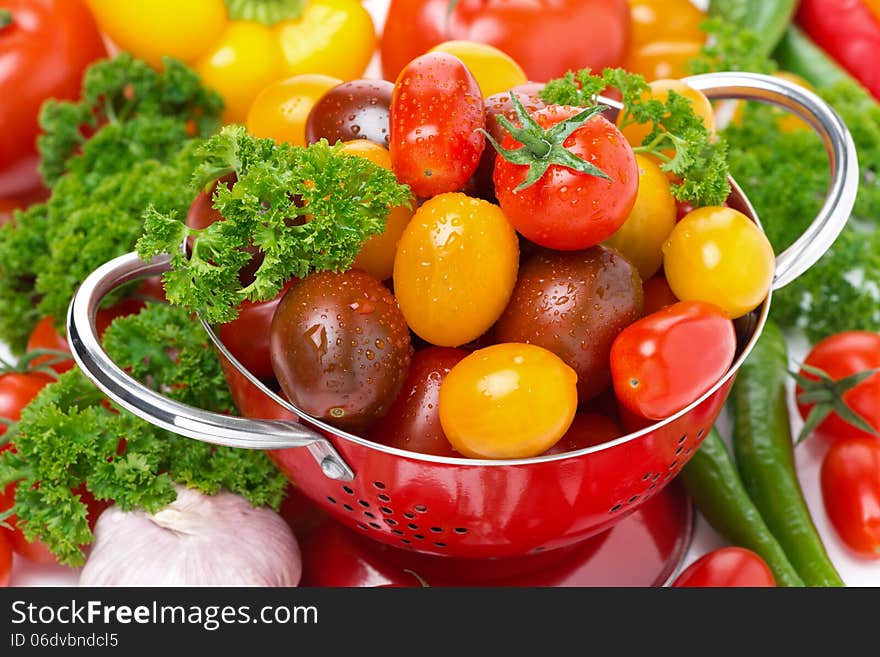 Assorted cherry tomatoes in a colander, garlic, spices and herbs