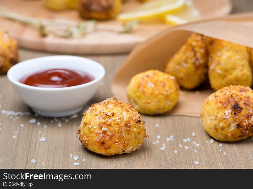 Chicken meatballs with tomato sauce on a wooden table, close-up, horizontal