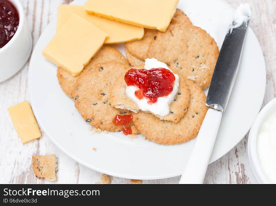 Crackers with cream cheese and berry jam for breakfast, close-up