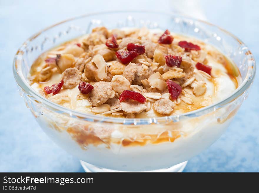 Dessert of natural yogurt with maple syrup, granola and nuts