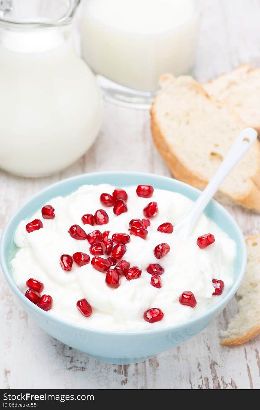 Homemade yogurt with pomegranate, milk and bread for breakfast