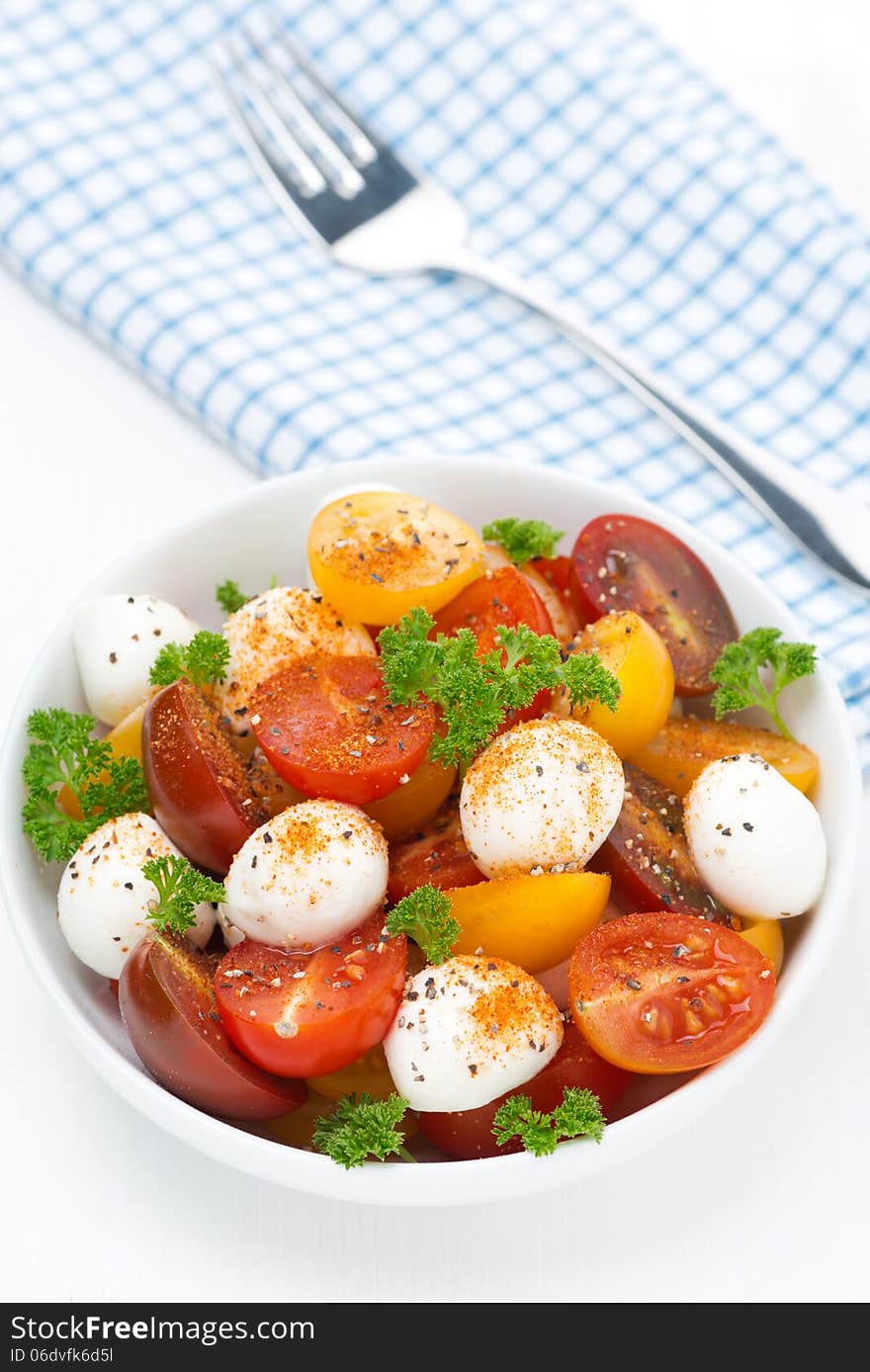 Salad with mozzarella and colorful cherry tomatoes, top view, vertical