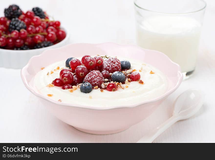 Semolina porridge with fresh berries, nuts and glass of milk, close-up, horizontal