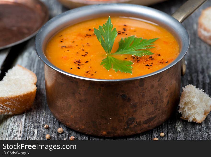 Spicy red lentil soup in a copper saucepan, close-up