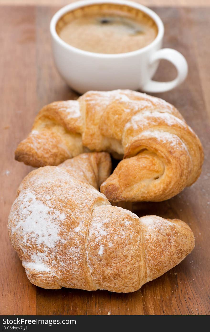 Two Fresh Croissants And Coffee On A Wooden Background