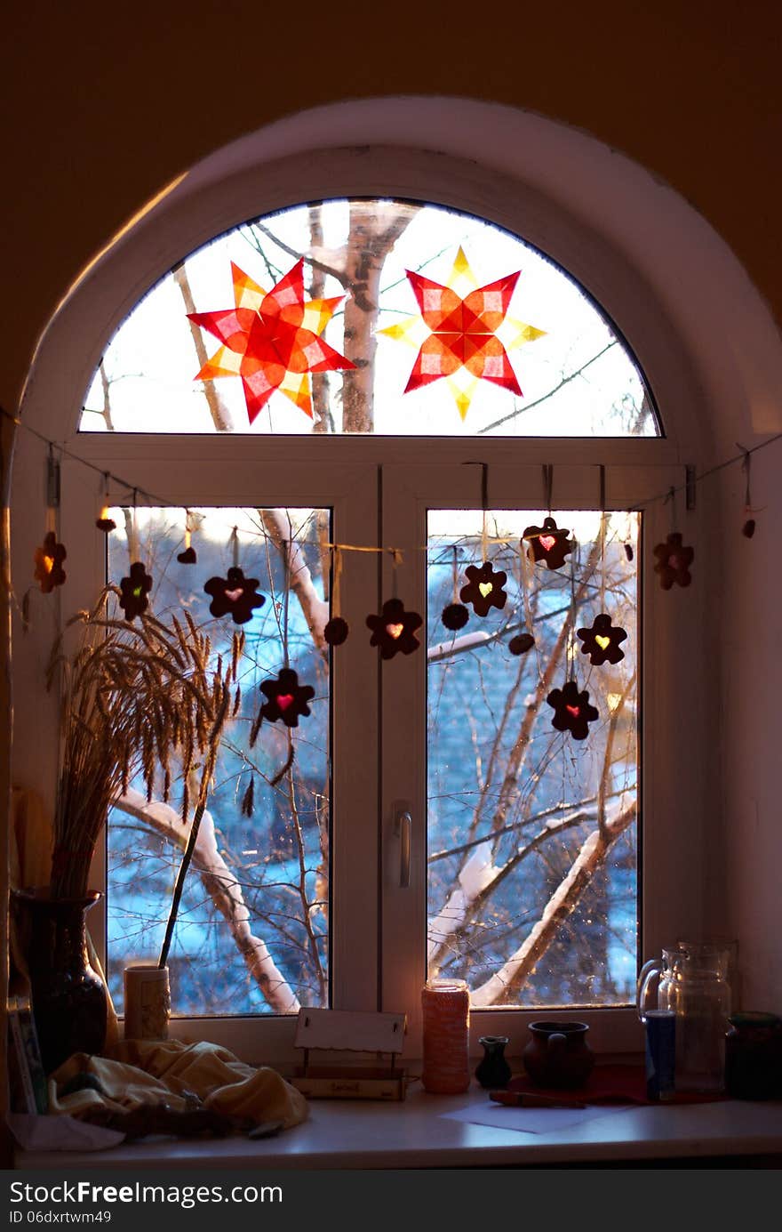 Window decorated with paper stars and a garland of gingerbread. Window decorated with paper stars and a garland of gingerbread