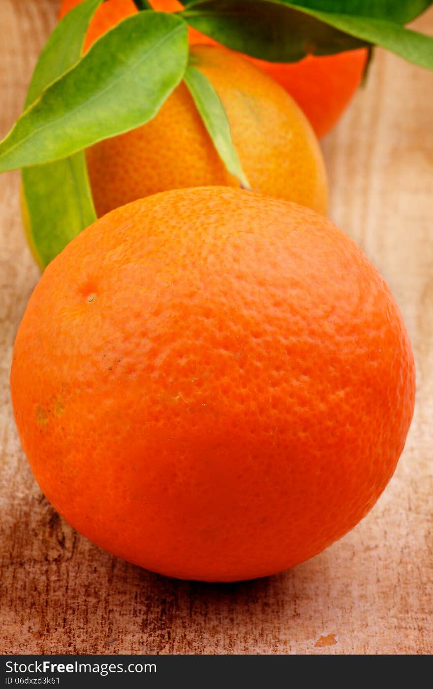 Fresh Ripe Tangerines with Stems and Leafs closeup on Rustic Wooden background