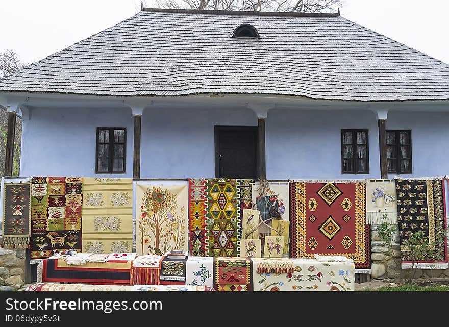 Various models of rugs and carpets exposed in front of a traditional peasant house. Various models of rugs and carpets exposed in front of a traditional peasant house.