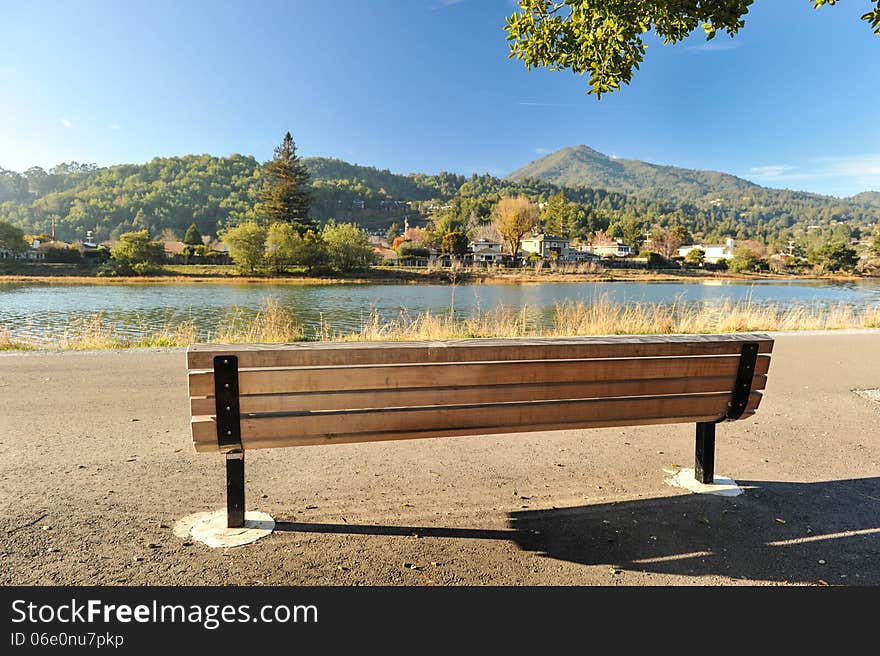 Wooden bench by a river with mountains