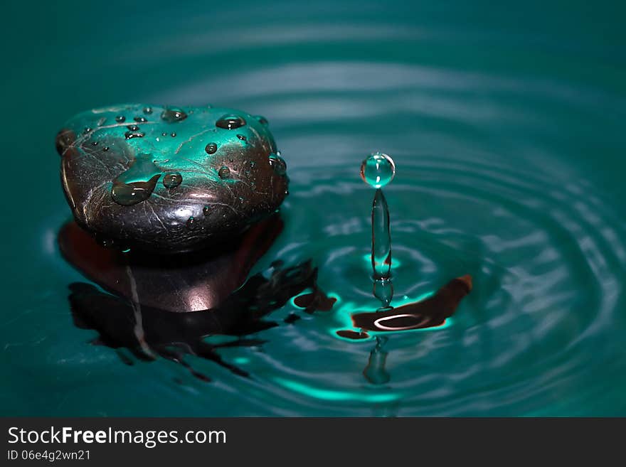 Meditation concept. Stone with drops in splashing water. Meditation concept. Stone with drops in splashing water