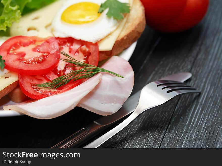 Closeup of plate with fried eggs and ham, toasts and cheese. Closeup of plate with fried eggs and ham, toasts and cheese