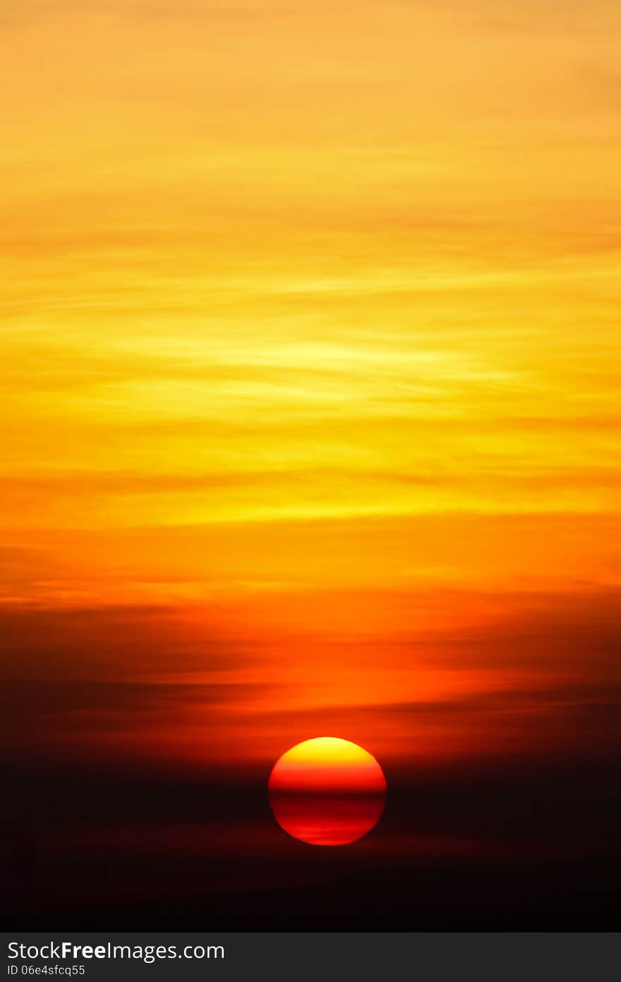 Striped rising sun behind yellow and orange clouds. Striped rising sun behind yellow and orange clouds