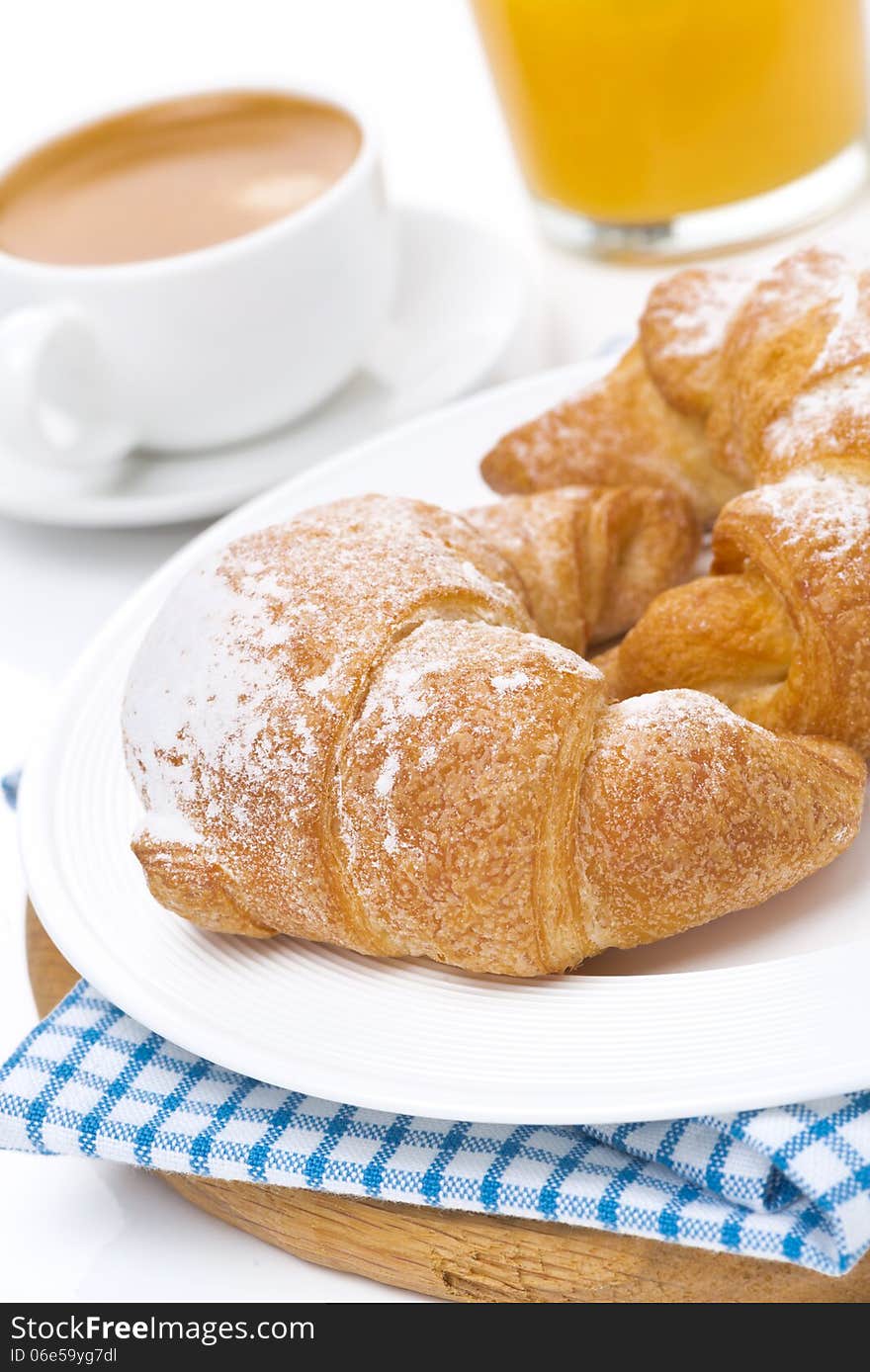 Croissants on a plate, espresso and orange juice, close-up