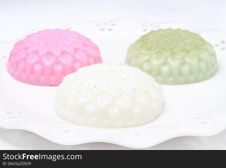 Different types of Panna cotta (raspberry, tea matcha, vanilla) on a plate horizontal closeup. Different types of Panna cotta (raspberry, tea matcha, vanilla) on a plate horizontal closeup