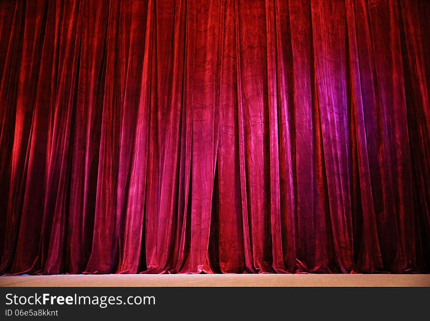 Closed crumpled red curtain over the scene. Closed crumpled red curtain over the scene