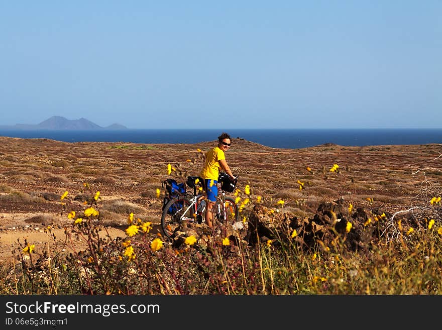 Woman in yellow riding bike on on Canary island. Woman in yellow riding bike on on Canary island