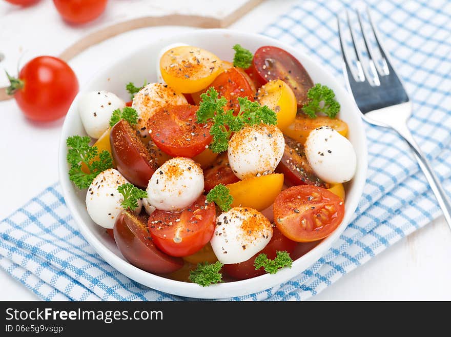 Salad with mozzarella, fresh herbs and colorful cherry tomatoes, close-up, horizontal