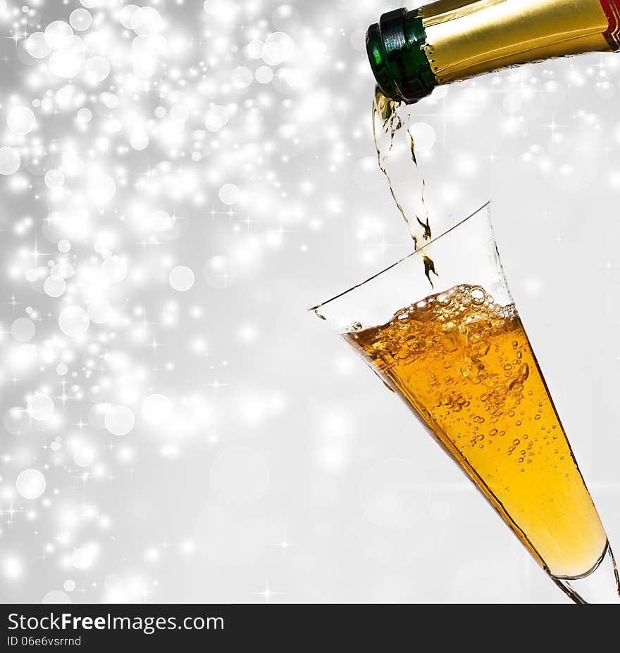 Pouring champagne against holiday lights