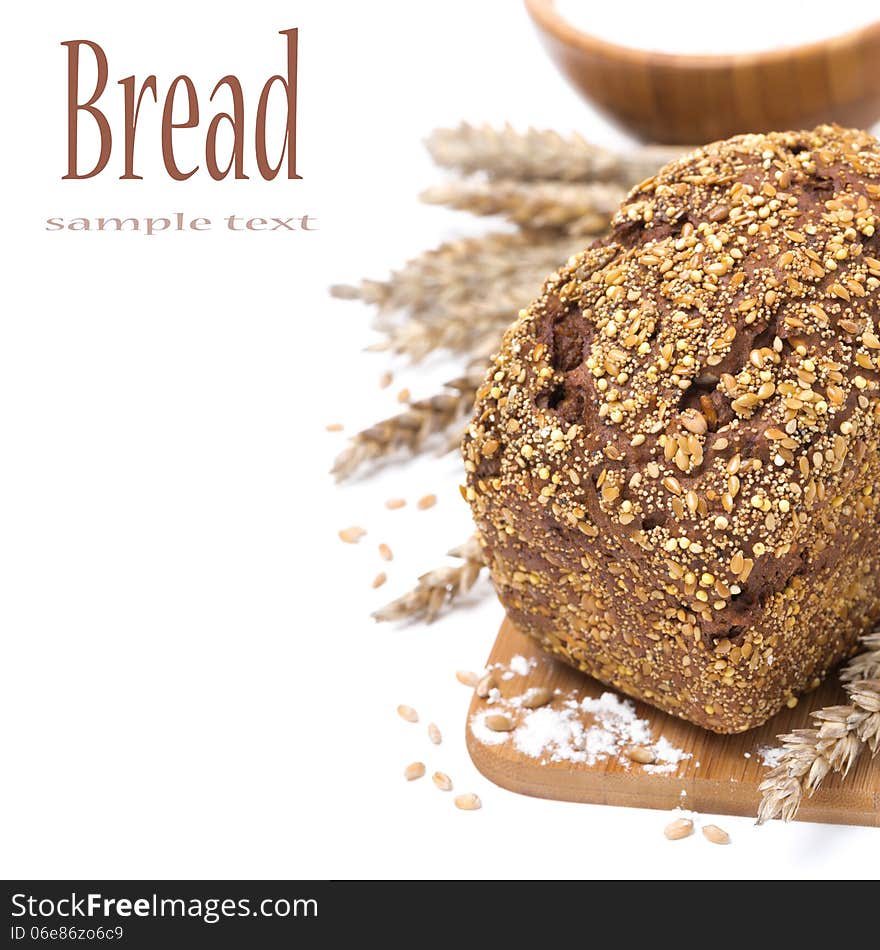 Whole grain bread with seeds and a bowl of flour, isolated on white