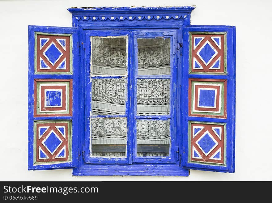 A window of a traditional peasant house with shutters. A window of a traditional peasant house with shutters