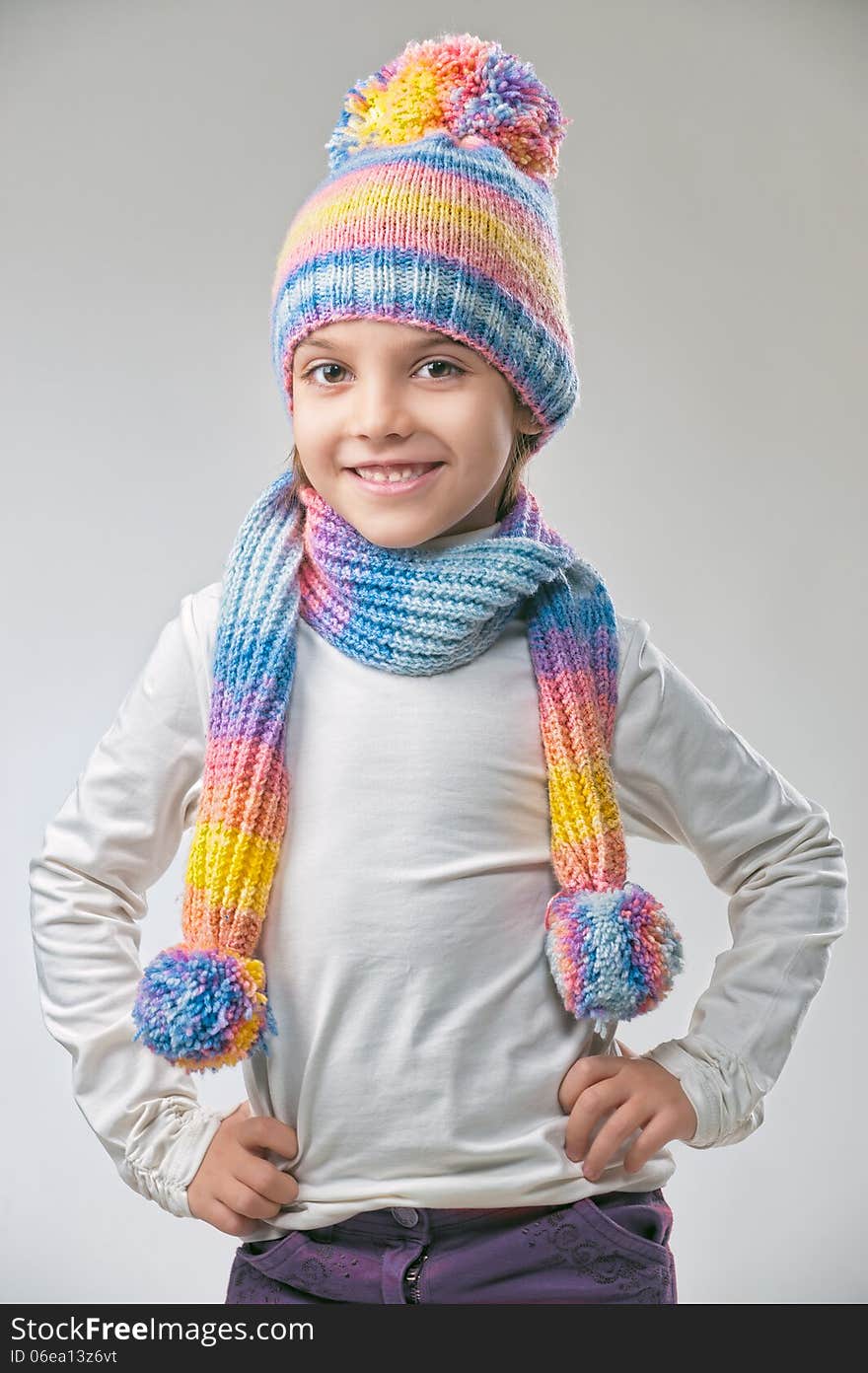 Portrait of girl in knitted hat and scarf on a light background. Portrait of girl in knitted hat and scarf on a light background