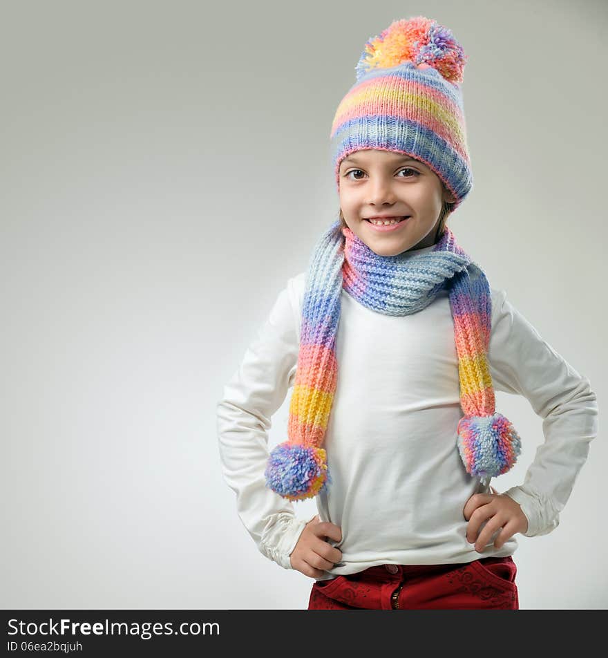 Portrait of girl in knitted hat and scarf on a light background. Portrait of girl in knitted hat and scarf on a light background