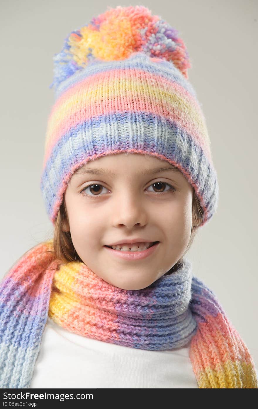 Portrait of girl in knitted hat and scarf on a light background. Portrait of girl in knitted hat and scarf on a light background