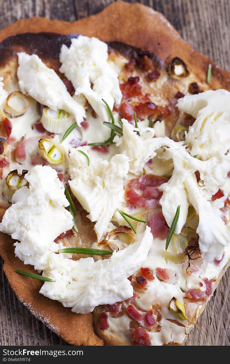 Closeup of flammkuchen on dark wood