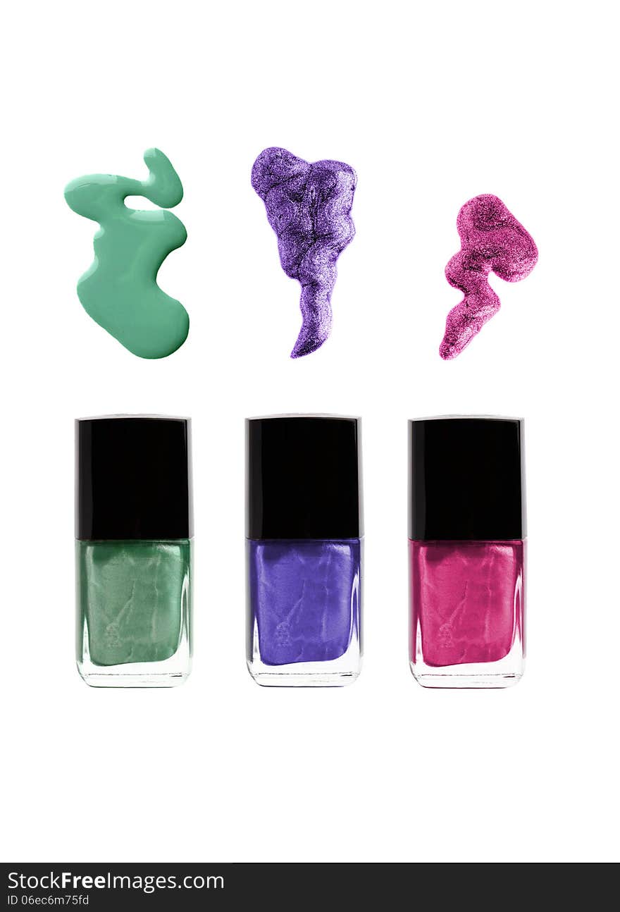 Nail polish bottles with spills: green, violet, purple or pink colors