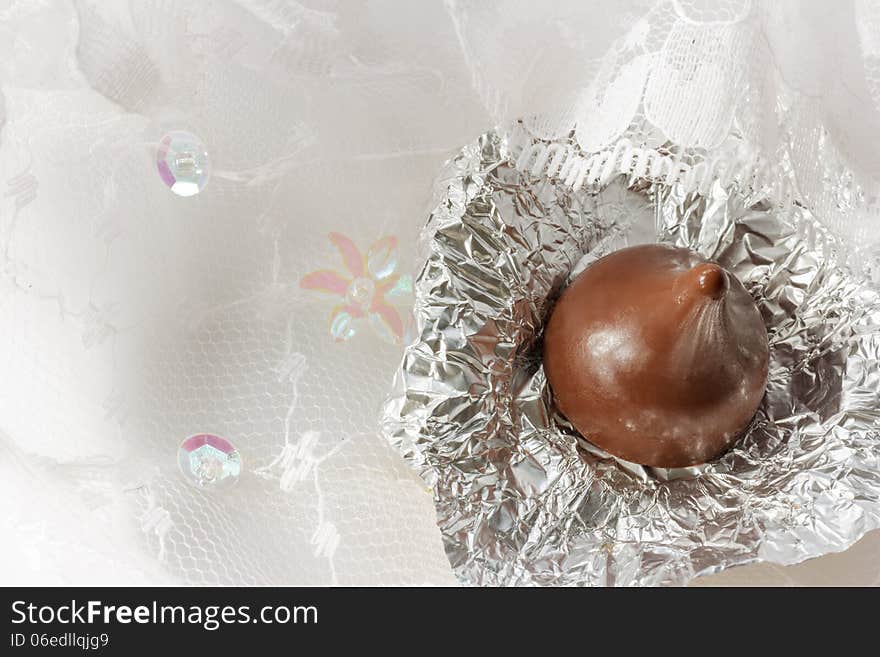 Chocolate with foil on lace background.