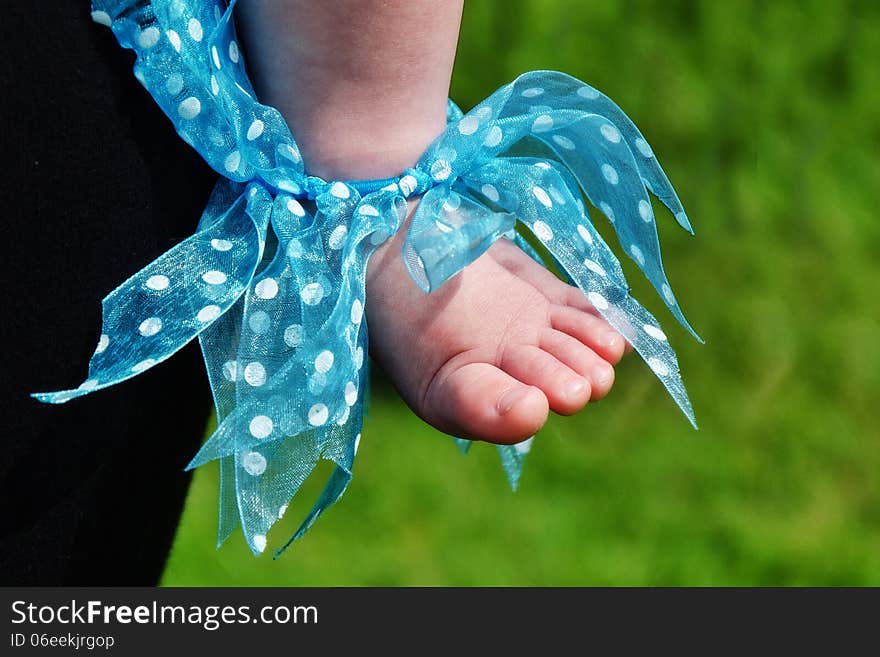 Close up of a baby's foot decorated with ribbons at a fair. Close up of a baby's foot decorated with ribbons at a fair.