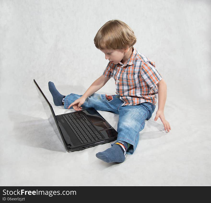 The boy turned on the laptop clicks on the keyboard. The boy turned on the laptop clicks on the keyboard