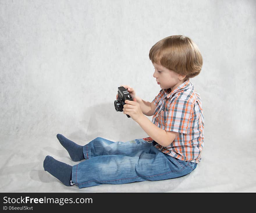 A boy takes pictures considers the camera makes settings. A boy takes pictures considers the camera makes settings