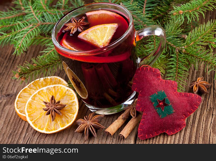 Christmas mulled wine in a glass on old wooden background