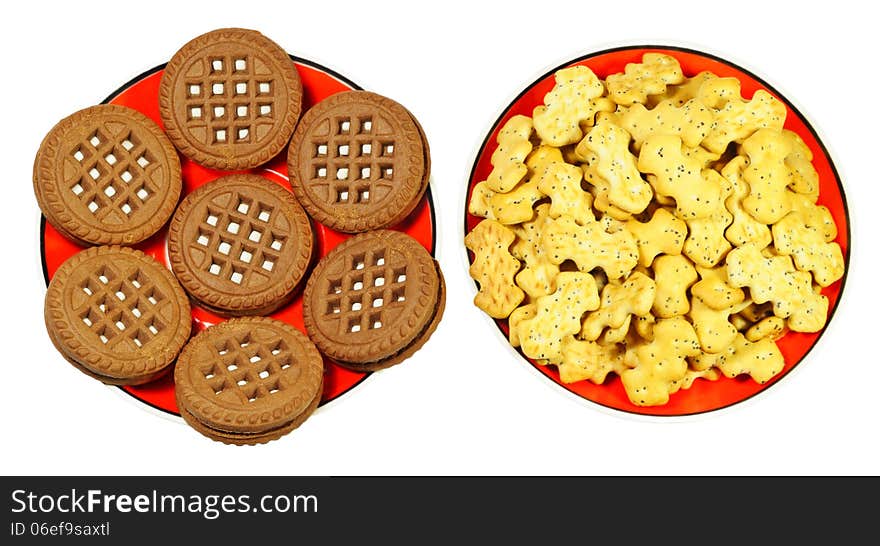 Two types of cookies on the red saucers, isolated on white background