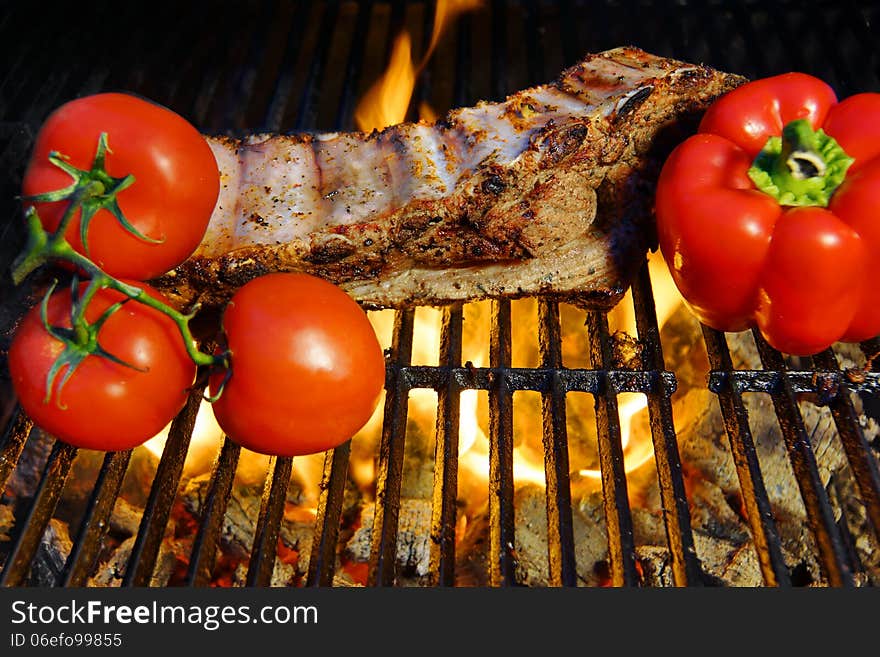 Ribs roasted in a barbecue with pepper and tomatoes